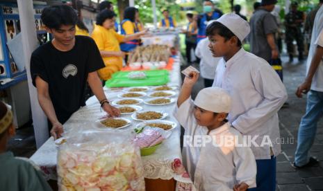 Warga mengantre mengambil takjil untuk berbuka puasa di Taman Suropati, Jakarta, Sabtu (23/3/2024). 