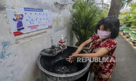 Seorang anak memakai masker saat mencuci tangan di kawasan Kampung Sehat, Utan Kayu Selatan, Jakarta, Sabtu (7/11). Anak muda cenderung lebih jarang mengalami gejala berat Covid-19. 