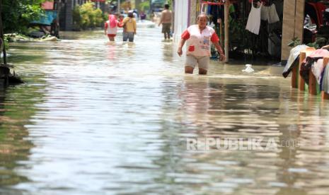 Warga berjalan menerobos banjir yang merendam Desa Suranenggala Lor, Kecamatan Suranenggala, Kabupaten Cirebon, Jawa Barat