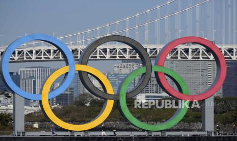  Pekerja berdiri di atas tongkang membawa monumen cincin Olimpiade di tepi laut Taman Laut Odaiba, di Tokyo, Jepang, 01 Desember 2020. Monumen cincin Olimpiade telah dipasang kembali ke lokasi aslinya setelah pekerjaan pemeliharaan. Olimpiade Tokyo 2020 telah dijadwalkan ulang menjadi 23 Juli 2021, karena pandemi virus corona.