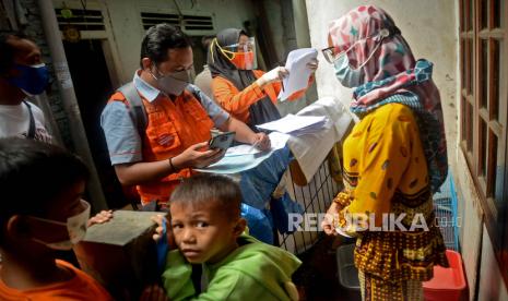 Petugas PT Pos Indonesia menyalurkan Bantuan Sosial Tunai (BST) kepada warga di Kawasan Kebon Jahe, Petojo Selatan, Jakarta, Rabu (21/7). Pemerintah kembali menyalurkan Bantuan Sosial Tunai (BST) senilai Rp. 600 ribu untuk dua periode yakni Bulan Mei - Juni 2021. 