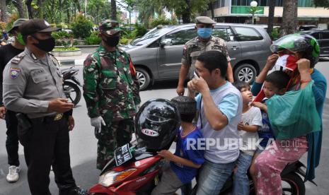 Personel TNI dan Polri menghentikan pengendara sepeda motor yang tidak menggunakan masker saat beraktivitas di Medan, Sumatra Utara, Rabu (6/5). Sumatra Utara mencatat lonjakan signifikan kasus Covid-19 pada Sabtu (9/5).