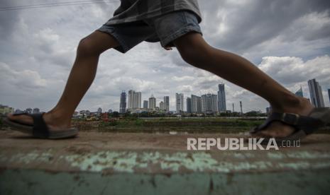 Seorang bocah berjalan dengan latar belakang gedung-gedung bertingkat di Jakarta, Selasa (24/11/2020). Menteri Keuangan Sri Mulyani Indrawati menyebutkan realisasi pendapatan negara hingga 31 Oktober 2020 menurun sebesar 15,4 persen (yoy) dari sebesar Rp1.508,5 triliun pada 2019 menjadi sebesar Rp1.276,9 triliun pada 2020 karena dipicu penerimaan perpajakan yang terkontraksi hingga 15,6 persen (yoy) yaitu Rp991 triliun atau 70,6 persen dari target perubahan APBN 2020 sebesar Rp1.404,5 triliun. 