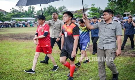 Presiden Joko Widodo (kiri) bersama Ketua Umum Partai SoIidaritas Indonesia (PSI) Kaesang Pangarep bermain bola dengan warga di Lapangan Gamplong, Sleman, Sabtu (27/1/2024). Meski bermain ditengah guyuran hujan, Presiden Jokowi tetap antusias bermain bola dengan warga. Menurut Jokowi, bermain bola dengan warga ini merupakan bentuk dukungan dan juga untuk menyemangati Timnas Indonesia yang lolos ke babak 16 besar Piala Asia.