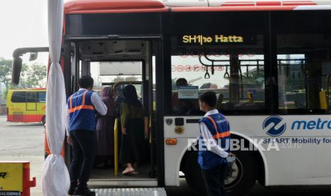 Penumpang menaiki bus Transjakarta rute Kalideres -Bandara Soekarno Hatta saat berhenti di Kalideres, Jakarta Barat, Jumat (7/7/2023).