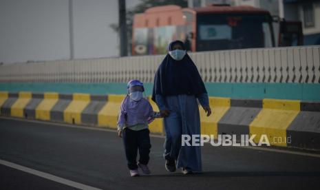 Warga menggunakan pelindung wajah saat berolahraga di Jalan Layang Non Tol (JLNT) Antasari-Blok M, Jakarta, Ahad (19/7). Pemprov DKI Jakarta menyediakan sebanyak 31 titik Kawasan Khusus Pesepeda (KKP)  sebagai pengganti Hari Bebas Kendaraan Bermotor (HBKB) yang berlaku pada hari minggu dari pukul 06.00 WIB hingga 09.00 WIB dengan tetap menerapkan protokol kesehatan.