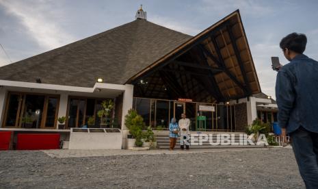 Warga berfoto di depan Masjid Jami Nurul Hasanah-Aceh di Palu, Sulawesi Tengah, Minggu (25/4/2021). Masjid yang dibangun kembali karena ambruk saat bencana di Palu dua tahun lalu itu adalah bantuan pemerintah dan masyarakat Aceh, yang pada Ramadhan ini banyak dikunjungi warga karena arsitekturnya yang unik memadukan rumah adat Palu dan Aceh. DMI Sulteng Mulai Program Rehabilitasi 250 Masjid