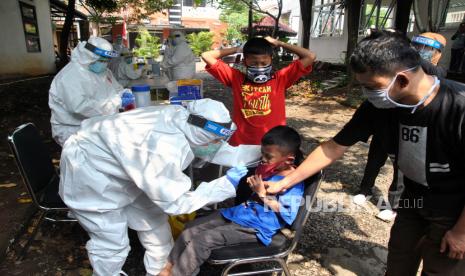 Petugas Dinas Kesehatan Kota Bogor mengambil sampel lendir seorang anak saat tes swab di Perumahan Cilendek Indah Green Garden, Kota Bogor, Jawa Barat, Sabtu (6/6). Kasus positif Covid-19 di Kota Bogor yang dinyatakan sembuh bertambah delapan orang lagi. 