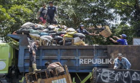 Petugas kebersihan memasukkan sampah ke dalam truk di Pasar Astanaanyar, Kota Bandung, Jawa Barat, 