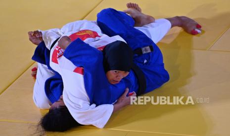 Judoka Papua Desi Rahayu (atas) bertarung melawan judoka Jawa Timur Luh Eka Meidiani (bawah) dalam babak perebutan medali perunggu nomor beregu campuran cabang judo PON Papua di Graha Eme Neme Yauware, Timika, Kabupaten Mimika, Ahad (3/10/2021). Papua menang dalam pertandingan itu dan meraih medali perunggu bersama Jawa Barat yang juga menang atas Jawa Tengah dalam babak yang sama. 