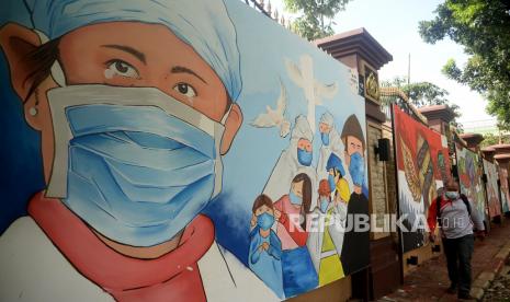 Indonesia Terima Jutaan Vaksin AstraZeneca dan Covovax. Pejalan kaki melintas didekat mural bertema covid-19 dikawasan Lapangan Bhayangkara, Jakarta, Rabu (1/12). Juru Bicara Vaksinasi Covid-19 Kementerian Kesehatan (Kemenkes) Siti Nadia Tarmizi mengatakan perkembangan situasi pandemi Covid-19 di Indonesia hingga saat ini masih terkendali.Prayogi/Republika.