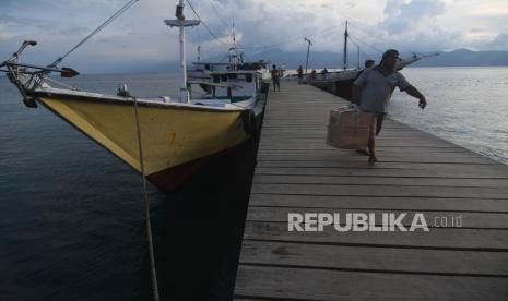 Warga membawa barang dari atas kapal yang bersandar ditambatan perahu yang dibangun dengan menggunakan dana desa di Desa Wani, Kabupaten Donggala, Sulawesi Tengah, Senin (11/4/2022). Tambatan perahu yang dibangun dengan menggunakan dana desa tersebut bermanfaat bagi masyarakat di desa tersebut yang sebagian besar  menggantungkan hidupnya dari aktivitas di laut baik sebagai nelayan ataupun buruh bongkar muat angkutan kapal. 