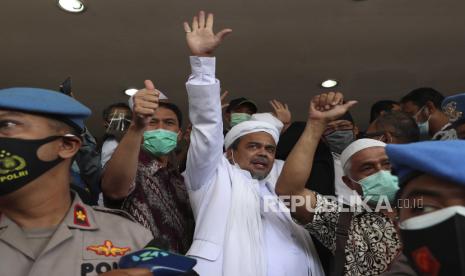 Pemimpin Front Pembela Islam Rizieq Shihab (tengah) melambaikan tangan pada wartawan setibanya di Mabes Polri di Jakarta, Indonesia. Sabtu (12/10), sebelum akhirnya ditahan dengan status tersangka kasus kerumunan massa di Petamburan, Jakarta. Pada Jumat (18/12) massa simpatisannya menggelar aksi 1812 di depan Istana Negara. (ilustrasi).