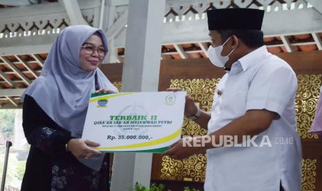 Wali Kota Bandung Yana Mulyana (kedua kiri) menyerahkan kadeudeuh bagi para juara Musabaqah Tilawatil Quran (MTQ) ke-37 Tingkat Provinsi Jawa Barat 2022 di Pendopo Kota Bandung, Rabu (6/7). Kafilah Kota Bandung berhasil menjadi juara umum MTQ ke-37 tingkat Jawa Barat, dan mempertahankan gelar ini untuk kesembilan kalinya secara beruntun.