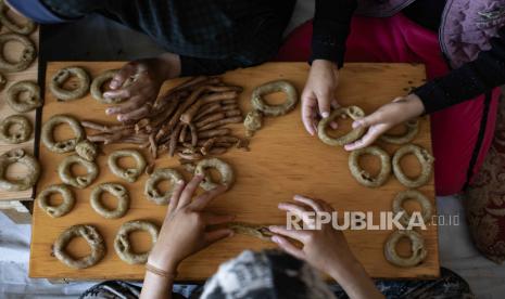 Perempuan pengungsi Palestina menyiapkan kue tradisional sebelum Idul Fitri, yang menandai akhir bulan suci Ramadhan, di dalam tenda di kamp Rafah di selatan Jalur Gaza, 09 April 2024.