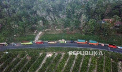 Foto udara kendaraan yang didominasi truk melintasi Jalan Lintas Sumatera di Sungai Landai, Muaro Jambi, Jambi, Jumat (14/4/2023). Arus lalu lintas di Jalan Lintas Sumatera yang menghubungkan Jambi dengan Sumatera Selatan itu terpantau meningkat dibanding hari sebelumnya dengan didominasi truk dan mobil pribadi.  