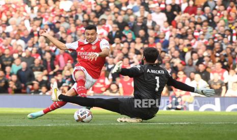 Pemain Arsenal Gabriel Martinelli (kiri) mencetak skor 1-0 melewati kiper Liverpool Alisson (kanan) selama pertandingan sepak bola Liga Premier Inggris antara Arsenal FC dan Liverpool FC di London, Inggris, 09 Oktober 2022.