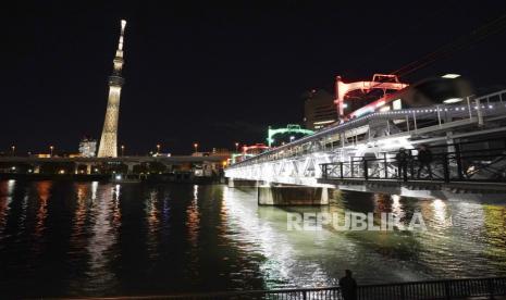 Tokyo Skytree, menara tertinggi di Jepang, diterangi dengan warna Obor Olimpiade, untuk memperingati 100 hari hingga estafet obor dimulai, Selasa, 15 Desember 2020, di Tokyo.