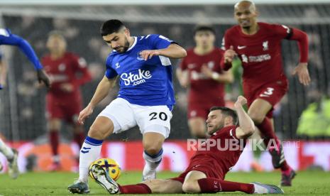 Pemain Liverpool James Milner (kanan) menekel pemain Everton  Neal Maupay (kiri) pada pertandingan sepak bola Liga Utama Inggris antara Liverpool FC dan Everton FC di Liverpool, Inggris, Selasa (14/2/2023) dini hari WIB.