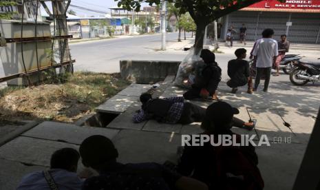 Pengunjuk rasa Myanmar berlindung saat mereka bersembunyi dari pasukan keamanan selama protes kudeta anti-militer di Mandalay, Myanmar, 03 April 2021. Setidaknya 535 orang telah dibunuh oleh militer sejak kudeta, menurut Asosiasi Bantuan untuk Tahanan Politik ( AAPP), sementara lebih dari 2.500 orang telah ditahan. 