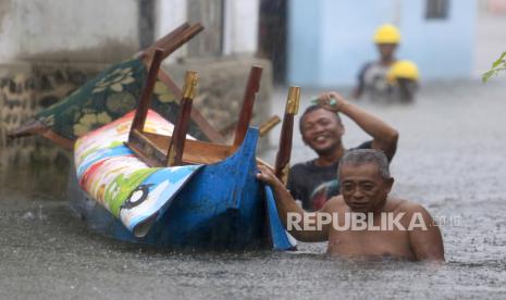 Dua warga mengevakuasi barang miliknya menggunakan perahu ketika banjir merendam di Desa Buhu, Kecamatan Telaga jaya, Kabupaten Gorontalo, Gorontalo, Rabu (10/7/2024). Dua desa yaitu Buhu dan Hutadaa terendam air luapan Danau Limboto hingga ketinggian mencapai 1,5 meter akibat hujan deras mengguyur daerah itu. 