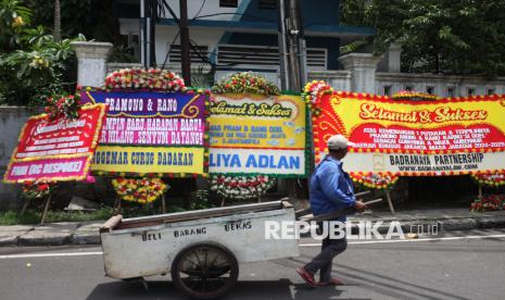 Warga melintasi karangan bunga yang berjejer di sekitar Rumah Pemenangan pasangan cagub dan cawagub DKI Jakarta Pramono Anung dan Rano Karno di Jalan Cemara, Jakarta, Sabtu (30/11/2024). Karangan-karangan bunga tersebut memenuhi kawasan sekitar posko pemenangan Pram-Rano usai pasangan cagub-cawagub yang diusung PDI Perjuangan itu unggul dalam perolehan suara Pilkada 2024 DKI Jakarta versi hitung cepat sejumlah lembaga survei dengan angka di atas 50 persen. 