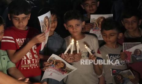 Anak-anak Palestina membawa lilin menyala dan foto-foto jurnalis Al Jazeera yang terbunuh Shireen Abu Akleh, untuk mengutuk pembunuhannya, di depan kantor jaringan Al Jazeera, di Kota Gaza, Rabu, 11 Mei 2022.