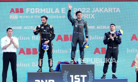 Pembalap Jaguar TCS Mitch Evans dari Selandia Baru melambai di podium setelah memenangkan balapan mobil E-Prix Formula E Jakarta sebagai Kepala Tim Jaguar TCS James Barclay, kiri, pemenang tempat kedua Jean-Eric Vergne dari Prancis DS Techeetah dan tempat ketiga Edoardo Mortara dari Rokit Venturi of Switzerland applaud, di Jakarta, Indonesia, Sabtu, 4 Juni 2022. BI DKI Jakarta menyebut ajang Formula E ikut mendorong perekonomian Jakarta. 