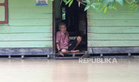 Seorang warga duduk di rumahnya yang terendam banjir di Aceh Barat, Aceh (ilustrasi). BMKG mencatat ada delapan daerah dengan kategori siaga. 