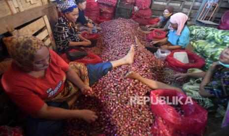 Pedagang membersihkan bawang merah di Pasar Induk Kramat Jati, Jakarta Timur, Rabu (25/3/2020).