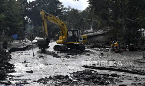 Satu unit alat berat dikerahkan untuk membersihkan material pasir Gunung Semeru yang menutupi jalan di Dusun Kamar Kajang, Candipuro, Lumajang, Jawa Timur, Kamis (9/12/2021). Pengerahan alat berat tersebut untuk mengangkat material pasir dan batu agar jalan dapat dilalui demi kelancaran proses evakuasi korban di wilayah itu dan di Jembatan Geladak Perak. 