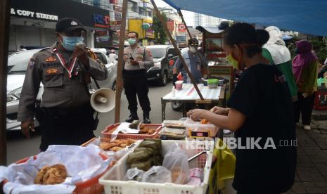 Anggota Polisi memberikan himbauan kepada para pembeli dan pedagang makanan berbuka puasa atau takjil.