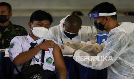 Petugas kesehatan melakukan vaksinasi COVID-19 kepada pelajar saat Serbuan Vaksinasi COVID-19 di GOR Bola Basket AAL Bumimoro, Surabaya, Jawa Timur, Rabu (21/7/2021). Komando Pembinaan Doktrin Pendidikan dan Latihan TNI Angkatan Laut (Kodiklatal) melaksanakan vaksinasi COVID-19 yang diperuntukkan untuk anak usia 12 tahun sampai dengan 17 tahun guna mewujudkan kekebalan komunal atau 