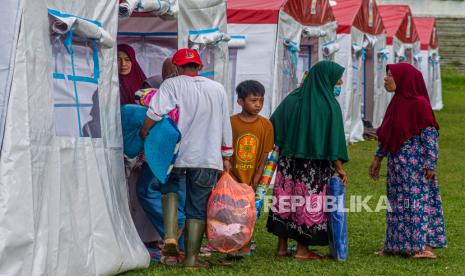  Warga membawa barang bawaannya saat pindah ke tenda khusus untuk lansia, perempuan dan anak-anak korban gempa berkekuatan 6,2 skala Richter, di Mamuju, Sulawesi Barat, Indonesia, 18 Januari 2021.  Kemensos  mengucurkan bantuan Rp 1,6 miliar uang santunan kepada keluarga korban yang meninggal akibat gempa bumi dengan magnitudo 6,2 di Sulawesi Barat.