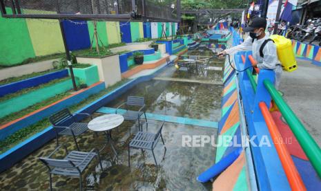 Warga menyemprotkan cairan disinfektan ke kursi dan meja di RW 4, Kelurahan Cibadak, Jalan Pagarsih, Kota Bandung, Kamis (1/10). Pemerintah Kota (Pemkot) Bandung bersama 9 lurah membahas rencana pemberlakuan mini lockdown di 9 kelurahan