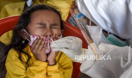 Petugas kesehatan dari Puskesmas Cikole mengambil sampel lendir dari seorang anak saat kegiatan rapid test antigen di halaman Kantor Kepala Desa Cibogo, Desa Cibogo, Kecamatan Lembang, Kabupaten Bandung Barat, Selasa (8/6). Dari hasil rapid test (tes cepat) antigen secara acak kepada 100 warga di desa tersebut, sebanyak 28 warga dinyatakan terkonfirmasi reaktif Covid-19 dan 72 warga lainnya non reaktif Covid-19. Foto: Republika/Abdan Syakura