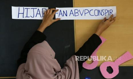 Kasus Pelarangan di Karnataka: Hijab Penting bagi Wanita Muslim. Foto: Seorang gadis Muslim India memperbaiki poster sebelum diskusi panel bertema 