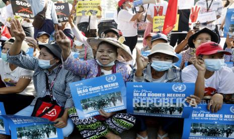 Demonstran memegang plakat yang menyerukan agar Perserikatan Bangsa-Bangsa mengambil tindakan, selama protes melawan kudeta militer Myanmar, di Yangon, Myanmar, 22 Februari 2021. Bisnis ditutup dan ribuan demonstran anti-kudeta turun ke jalan untuk pemogokan umum nasional yang dijuluki Pemberontakan 22222 atau Lima Dua, mengacu pada tanggal, 22 Februari 2021, meskipun junta militer memperingatkan tentang kekuatan yang mematikan.