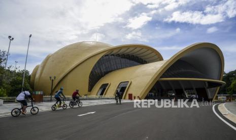 Pengunjung bersepeda di area Teater Keong Mas di Taman Mini Indonesia Indah (TMII), Jakarta. Pengelola TMII bersiap menyambut kedatangan wisatawan pada libur Lebaran 2025.