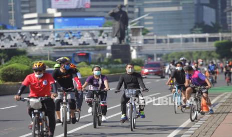 Warga bersepeda  melintasi jalan Sudirman, Jakarta, Ahad (28/3/2021). Pemerintah Provinsi DKI Jakarta memperpanjang masa pemberlakukan pembatasan kegiatan masyarakat (PPKM) mikro hingga 5 April 2021. 