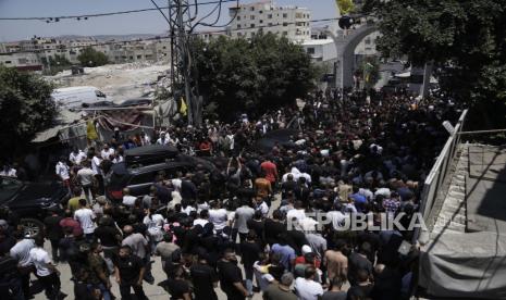 Para simpatisan Presiden Palestina Mahmoud Abbas menyambut di kamp pengungsi Jenin di Tepi Barat, Rabu, (12/7/2023). Kunjungan Abbas perjalanan pertamanya ke kamp tersebut sejak 2005 dilakukan seminggu setelah serangan maut Israel di Jenin yang meninggalkan kehancuran luas di belakangnya.