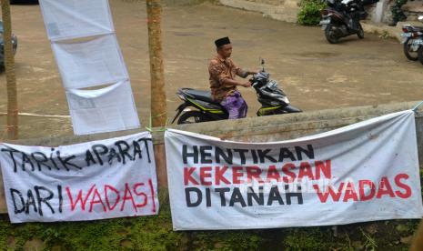 Spanduk penolakan kekerasan masih terpasang di sudut Desa Wadas, Purworejo, Jawa Tengah, Senin (14/2/2022). Kegiatan warga berlangsung normal pascapenarikan aparat kepolisian dari Desa Wadas. Kondisi desa juga mulai kondusif pascapenangkapan warga pekan lalu. Diketahui 63 warga ditangkap kepolisian bersamaan dengan pengukuran tanah warga yang setuju dengan penambangan batu andesit untuk Bendungan Bener di Wadas.