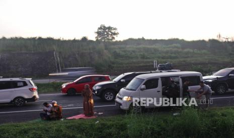 Pemudik melakukan shalat shubuh saat diberlakukan sistem satu arah Tol Cipali Km 141, Indramayu, Jawa Barat, Jumat (6/5/2022). Kepolisian memberlakukan //one way// arus balik secara dinamis dan melihat situasi kepadatan arus kendaraan pemudik.  Foto: Tahta Aidilla/Republika.