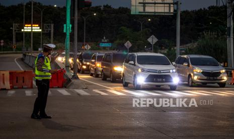 Petugas kepolisian mengatur lalu lintas kendaraan roda empat dari arah Jakarta yang akan keluar Gerbang Tol Kaliwungu, Kabupaten Kendal, Jawa Tengah, Jumat (29/4/2022). Pihak kepolisian melakukan skema pecah arus ke pintu keluar gerbang tol tersebut guna mengantisipasi terjadinya kemacetan atau penumpukan kendaraan roda empat dari arah Jakarta yang akan menuju Gerbang Tol Kalikangkung Semarang. 