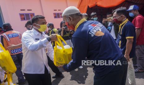 Bupati Batang Wihaji (dua kiri) memberikan bantuan sembako kepada tukang parkir di Posko Terpadu Gugus Tugas Percepatan Penanganan COVID-19 Kabupaten Batang, Jawa Tengah, Rabu (22/4/2020). Selain memberikan bantuan kepada 350 tukang parkir dan 311 pedagang pasar tiban, pemerintah setempat juga memberikan bantuan kepada 52 warga binaan asimilasi agar tidak melakukan kriminalitas setelah dibebaskan dan membantu meringankan beban warga saat wabah virus Corona (COVID-19)