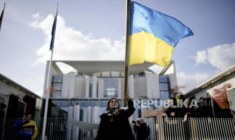 Seorang wanita mengibarkan bendera Ukraina (ilustrasi). 