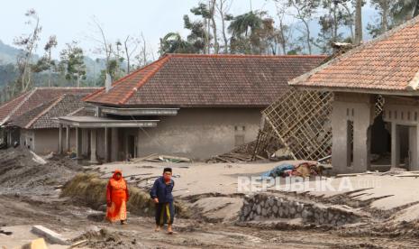 Warga melitas  di dekat rumah yang tertimbun material vulkanik gunung Semeru di dusun Umbulan, Pronojiwo, Lumajang, Jawa Timur, Rabu (8/12/2021). Pemerintah melalui Badan Geologi Kementerian Energi dan Sumber Daya Mineral (ESDM) akan menurunkan tim ahli untuk memperbarui peta Kawasan Rawan Bencana Gunung Semeru di Jawa Timur. 