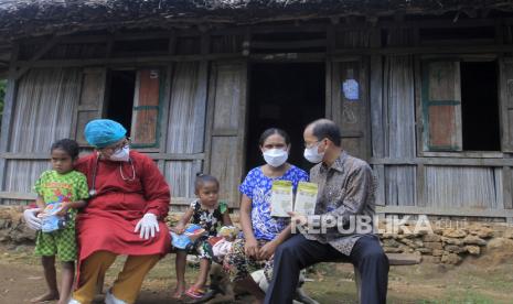 Pemimpin Perum Bulog Kantor Wilayah NTT Asmal (kanan) memberikan beras bergizi fortivit kepada seorang ibu dalam kegiatan Program Unggulan Bulog Peduli Gizi di desa Bokong, Kabupaten Kupang, NTT, Kamis (2/12/2021). Dalam rangka mencegah semakin meluasnya angka stunting di Kabupaten Kupang, Perum Bulog wilayah NTT menyediakan 5 ton beras fortivit bagi 352 balita bawah garis merah (BGM) yang akan terus dibagikan selama tiga bulan ke depan. 