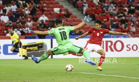 Hassan Sunny dari Singapura, depan, mencoba menghadang umpan silang Witan Sulaeman dari Indonesia pada pertandingan leg kedua semifinal Piala Suzuki AFF 2020 antara Indonesia dan Singapura di Singapura, Sabtu 25 Desember 2021. Polda Metro Jaya mengizinkan para pemilik kafe untuk menggelar nonton bareng (nobar) Final Piala AFF 2020 saat Timnas Indonesia menghadapi Thailand.