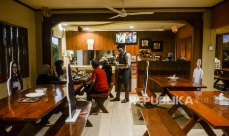 Pelayan menggunakan alat pelindung diri saat melayani pengunjung di Rumah Makan Bumi Aki, Pajajaran, Kota Bogor, Jawa Barat (ilustrasi). Pemkot Bogor menyatakan, pelaku usaha hotel dan restoran bisa mendapatkan nilai hibah pariwisata yang berbeda sesuai kontribusi pajaknya pada 2019.